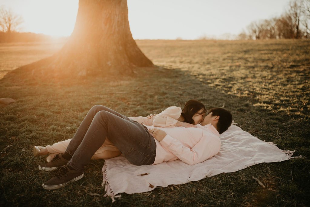 engagement photos of a couple laying down at sunset