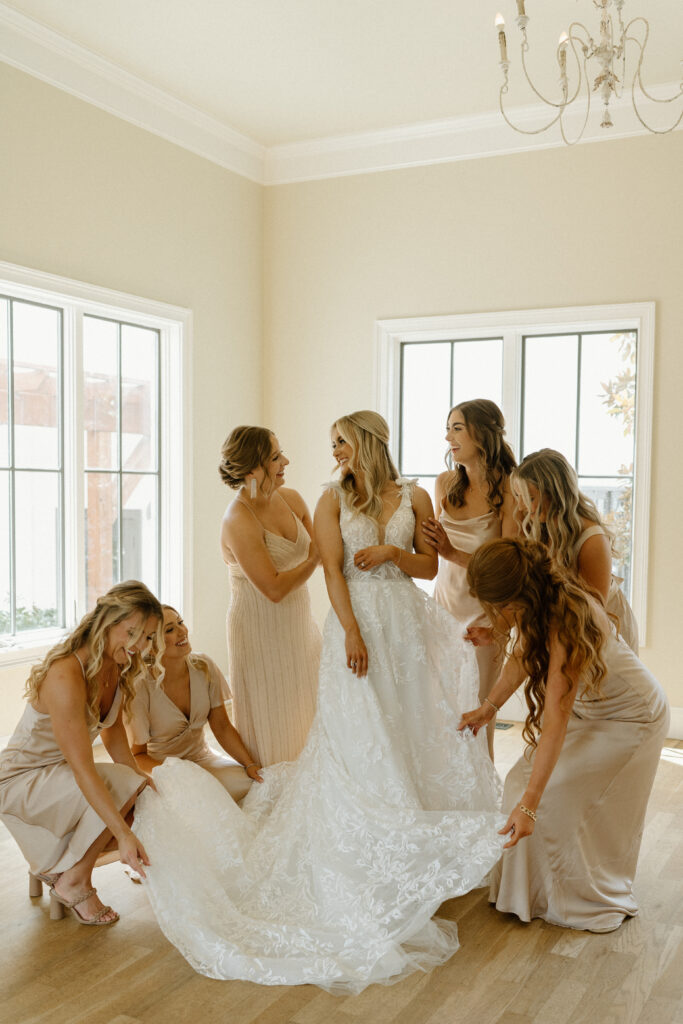brides friends help her get dressed