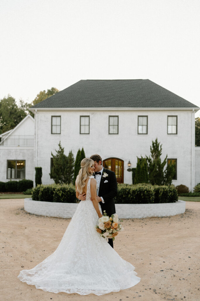 bride and groom take photos in front of wedding venue